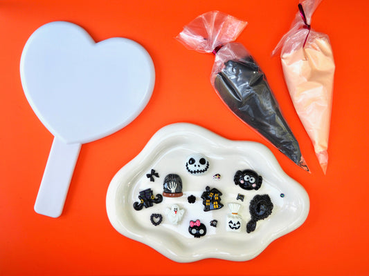 Decorative items including a heart-shaped mirror and halloween charms and glue